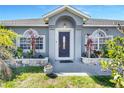 Close up featuring front door flanked by decorative windows and landscaping creating an inviting entrance at 9295 Melody Cir, Port Charlotte, FL 33981