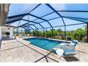 Screened in pool area including pavers and two in-pool lounging chairs perfect for relaxation at 10233 St Paul Dr, Port Charlotte, FL 33981