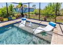 An in-pool view of the lounging chairs and a small turtle figurine in screened-in pool area at 10233 St Paul Dr, Port Charlotte, FL 33981