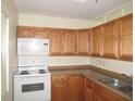 Efficient kitchen with white appliances and wood cabinets offering ample storage at 139 Dow Rd, Port Charlotte, FL 33952