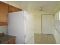 Kitchen space featuring a refrigerator, cabinets, tiled floor, and a ceiling fan at 139 Dow Rd, Port Charlotte, FL 33952