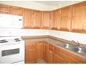 Well-lit kitchen with white appliances, warm wood cabinetry, and durable countertops at 139 Dow Rd, Port Charlotte, FL 33952