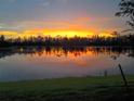 Stunning sunset view over the water, casting vibrant orange and yellow reflections across the tranquil lake at 14271 Heritage Landing Blvd # 1516, Punta Gorda, FL 33955