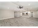 Open-concept living space with gray vinyl flooring and a ceiling fan, connecting seamlessly to the modern kitchen at 16031 Hesta Misty Ct, Punta Gorda, FL 33955