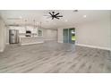 Open-concept living space with modern gray flooring, a ceiling fan, and sliding glass doors at 16098 Overdale Ct, Punta Gorda, FL 33955