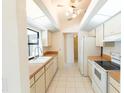 Bright kitchen with white cabinets, a window over the sink, and tile flooring, ready for cooking at 1612 Blue Lake Cir, Punta Gorda, FL 33983