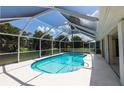 Screened-in pool offering a refreshing oasis surrounded by lush greenery and bathed in sunlight at 1612 Blue Lake Cir, Punta Gorda, FL 33983