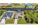 Aerial view of waterfront home with a pool, boat dock, and solar panels on a beautifully landscaped property at 17368 Skipper Ln, Port Charlotte, FL 33948