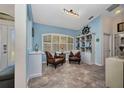 Sitting room with decorative shelving, shutters, two leather chairs and tile flooring at 17368 Skipper Ln, Port Charlotte, FL 33948