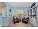Sitting room with decorative shelving, shutters, two leather chairs and tile flooring at 17368 Skipper Ln, Port Charlotte, FL 33948