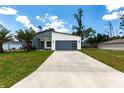 Attractive home with modern facade and attached garage complemented by a lush green lawn at 19160 Ruskin Ave, Port Charlotte, FL 33954