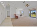 Bright living room featuring a neutral color scheme, ceiling fan, and sliding glass doors to lanai at 1981 Arena Ln, North Port, FL 34286