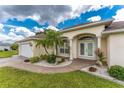 Inviting entrance featuring white columns, complemented by manicured landscaping with tropical plants and white gravel accents at 2168 Calcutta Rd, Punta Gorda, FL 33983