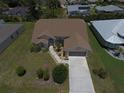 Beautiful home with a well-manicured lawn, long driveway, and lush landscaping at 23090 Ambassador Ave, Port Charlotte, FL 33954