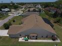 Back exterior view of a home with well-maintained landscaping and a screened-in pool area at 23090 Ambassador Ave, Port Charlotte, FL 33954