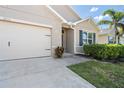 Garage and partial front exterior showing the well-maintained lawn and garden near the front entrance at 25312 E Lenox Cir, Punta Gorda, FL 33950