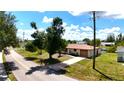 Well-maintained home with a long driveway and lush greenery, located on a quiet street at 27193 And 27197 Voyageur Dr, Punta Gorda, FL 33983
