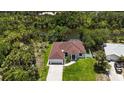 Aerial view of a single-story home nestled on a lot with mature landscaping and water views at 2955 Carmela Ave, North Port, FL 34286