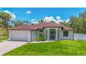 Charming single-story home with a brick driveway, manicured lawn, and a two-car garage at 2955 Carmela Ave, North Port, FL 34286