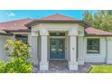 Inviting home featuring a blue front door, white columns, and manicured landscaping at 2955 Carmela Ave, North Port, FL 34286