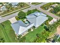 Aerial view of the property showing the house, metal roof, green lawn, driveway, mature landscaping, and surrounding neighborhood at 329 W Grace St, Punta Gorda, FL 33950
