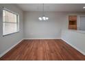 Open dining area with laminate wood floors and a stylish chandelier, perfect for Gathering meals at 406 Merlin Ct, Brandon, FL 33510