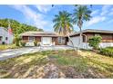 Charming single-story home featuring a palm tree, double-door entry, and beautiful landscaping at 6916 Rex Ln, Sarasota, FL 34243
