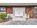 Close up on the home's front entrance with double doors, sconces, and tidy landscaping at 6916 Rex Ln, Sarasota, FL 34243