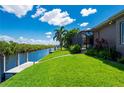 Lovely backyard with lush grass, dock, water access, and a screened-in lanai, perfect for outdoor entertaining at 695 Macedonia Dr, Punta Gorda, FL 33950