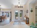 Foyer showcasing a beautiful double-door entrance with decorative glass, tile flooring, and dining room access at 85 Long Meadow Ct, Rotonda West, FL 33947