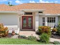 Inviting front entrance showcasing double doors, manicured landscaping, and a well-maintained walkway at 85 Long Meadow Ct, Rotonda West, FL 33947