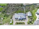 Expansive home with manicured lawn, private dock with boat lift, lush landscaping, and a circular driveway at 10161 Eagle Preserve Dr, Englewood, FL 34224