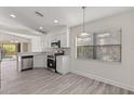 Bright kitchen with stainless steel appliances, white cabinets, breakfast bar, and backyard views at 118 Naomi Pl, Rotonda West, FL 33947