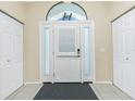Bright foyer with tiled floor, decorative transom window, and convenient closet space at 12185 Weimar Ave, Port Charlotte, FL 33981