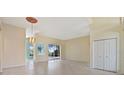 Bright living room featuring tile flooring, neutral walls, and sliding glass doors at 13783 Palmetto Point Ct, Port Charlotte, FL 33953