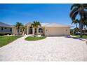 A home exterior shows a well-manicured lawn, brick driveway, and a two car garage at 1435 Pine Island Ct, Punta Gorda, FL 33950