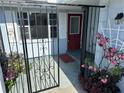 Welcoming front porch with security gate and colorful flowering plants at 1505 Kenmore St, Port Charlotte, FL 33952