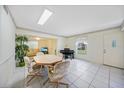 Open-concept dining area with adjacent living room features tile floors, piano, and natural light at 1596 Hayworth Rd, Port Charlotte, FL 33952