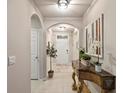 An interior hallway decorated with a side table, decorations and arched doorways at 16032 Galiano Ct, Punta Gorda, FL 33955