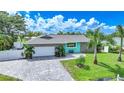 Charming single-story home featuring stone accents, a paved driveway, and lush landscaping with palm trees at 192 Danforth S Dr, Port Charlotte, FL 33980