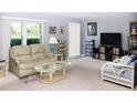 Inviting living room with large windows, neutral walls and carpeting at 2119 Pellam Blvd, Port Charlotte, FL 33948