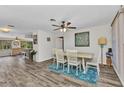 Bright dining room featuring wood floors, ceiling fan, stylish rug, and access to kitchen and living spaces at 2626 Auburn Blvd, Port Charlotte, FL 33948
