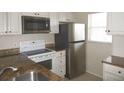 Close-up of the kitchen featuring granite countertops and stainless steel appliances at 26430 Rampart Blvd # 511, Punta Gorda, FL 33983