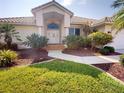 Inviting front entrance with tropical landscaping leading to a neutral-toned home with a tile roof at 3518 Terin Ct, Punta Gorda, FL 33950