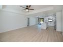 Open floor plan featuring light wood floors and white walls, with the kitchen visible in the background at 359 Salisbury St, Port Charlotte, FL 33954