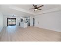 Bright living room with hardwood floors, modern ceiling fan, and an open layout that flows into the kitchen area at 359 Salisbury St, Port Charlotte, FL 33954
