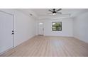 Bright living room with hardwood floors, modern ceiling fan, and an open layout featuring a front door at 359 Salisbury St, Port Charlotte, FL 33954