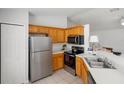 Functional kitchen with stainless steel appliances, light wood cabinets, and a breakfast bar for casual dining at 3886 Cincinnati St, North Port, FL 34286