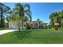 Well-maintained home with lush green lawn, mature trees, and an American flag at 4092 Troost St, North Port, FL 34288