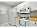 Functional kitchen features white appliances and light wood countertops at 410 Cerromar S Cir # 240, Venice, FL 34293